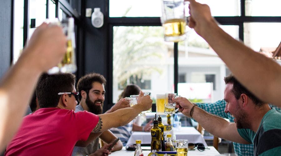 Photo of happy people giving a toast with beer